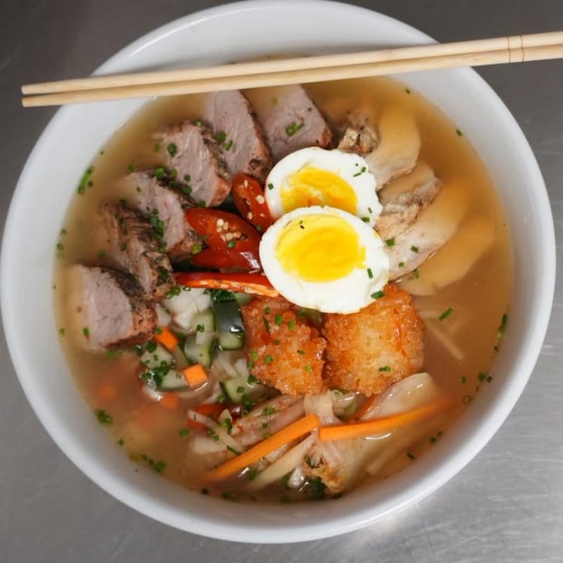 SinDo PanAsian Cuisine's ramen bowl with pork, soft-boiled eggs, vegetables, and crispy fried tofu.